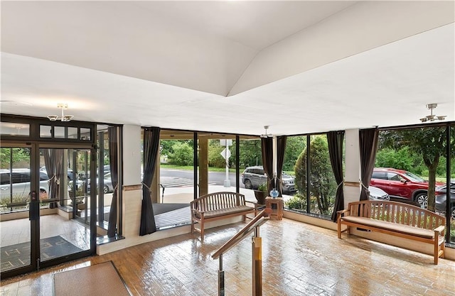 sunroom with a chandelier and vaulted ceiling