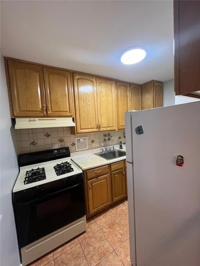 kitchen with decorative backsplash, light tile patterned flooring, white appliances, and sink