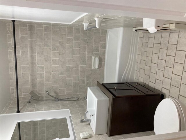 bathroom featuring tile patterned flooring and tile walls