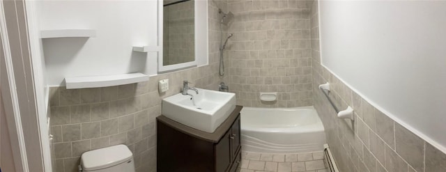 full bathroom with vanity, bathing tub / shower combination, toilet, baseboard heating, and tile walls