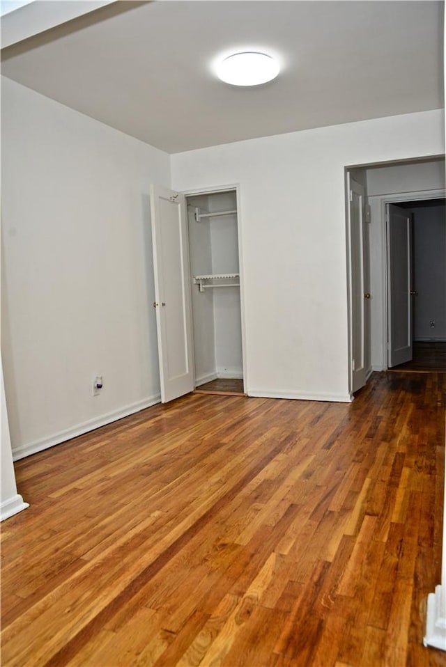 unfurnished bedroom with hardwood / wood-style flooring and a closet