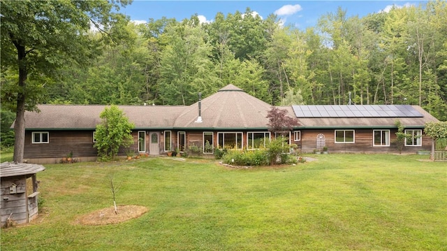 view of front of property featuring solar panels and a front lawn