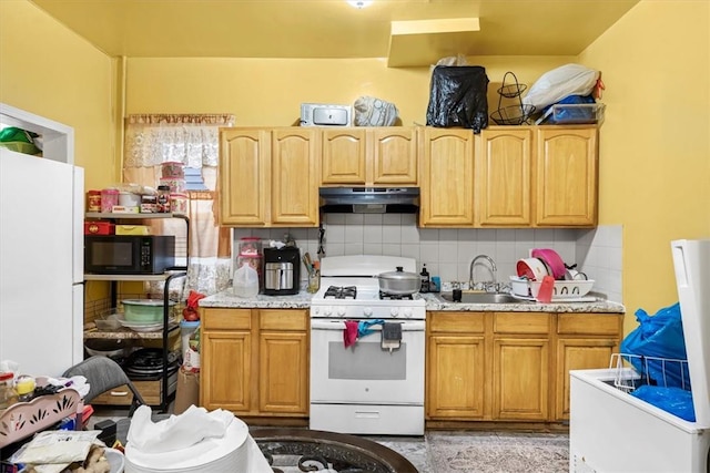 kitchen featuring decorative backsplash, sink, and white appliances