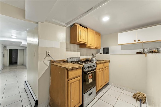 kitchen with backsplash, black gas stove, light tile patterned floors, and baseboard heating