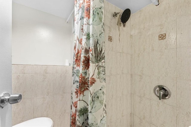 bathroom featuring a shower with curtain, toilet, and tile walls