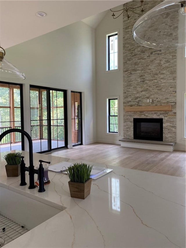 unfurnished living room with a fireplace, high vaulted ceiling, and wood-type flooring