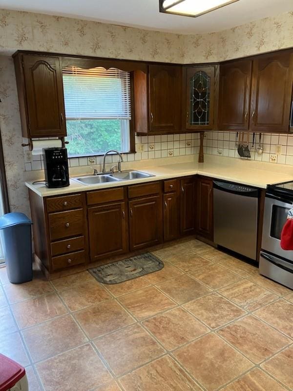 kitchen with tasteful backsplash, sink, dark brown cabinets, and appliances with stainless steel finishes