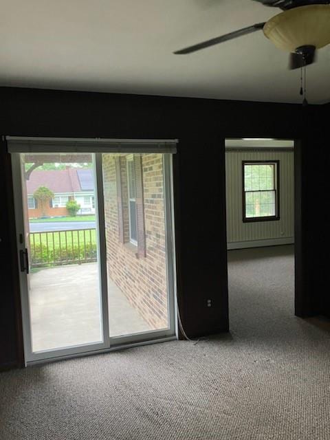 carpeted spare room featuring ceiling fan