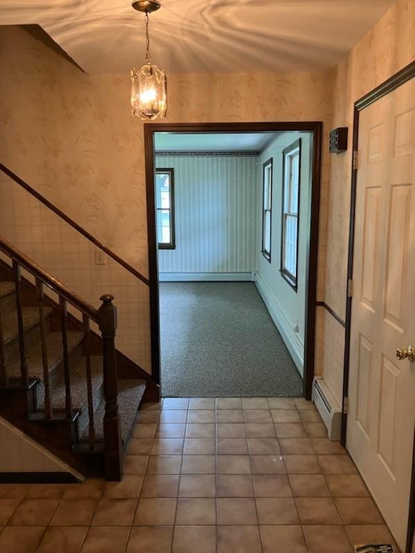 interior space with tile patterned floors, an inviting chandelier, and baseboard heating