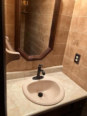 bathroom featuring vanity and tile walls