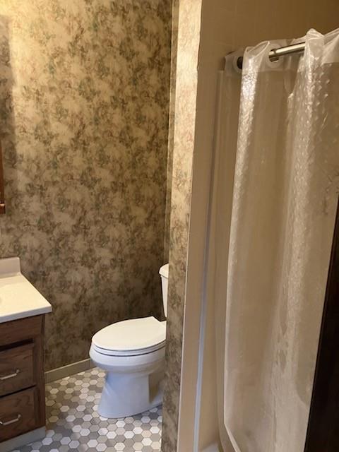 bathroom with tile patterned flooring, vanity, and toilet