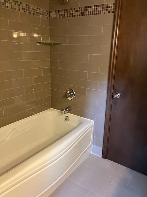 bathroom featuring tile patterned flooring and tiled shower / bath