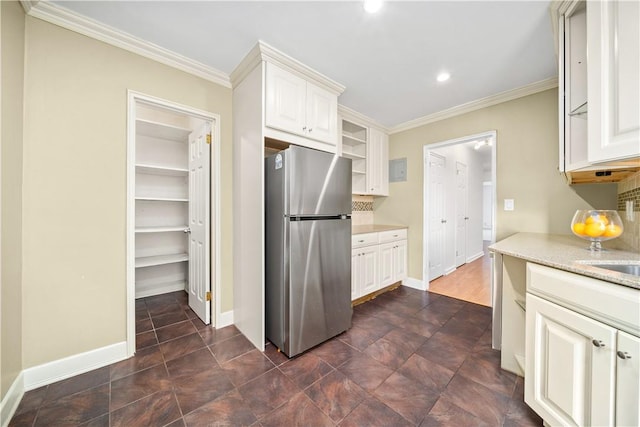 kitchen featuring stainless steel fridge, white cabinetry, and crown molding