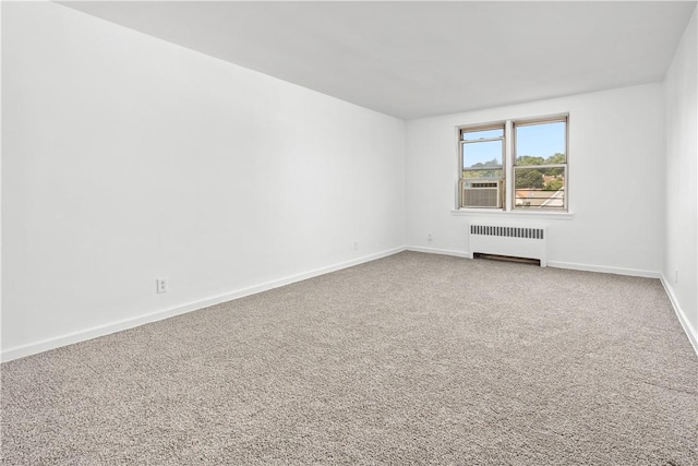 carpeted empty room featuring radiator and cooling unit