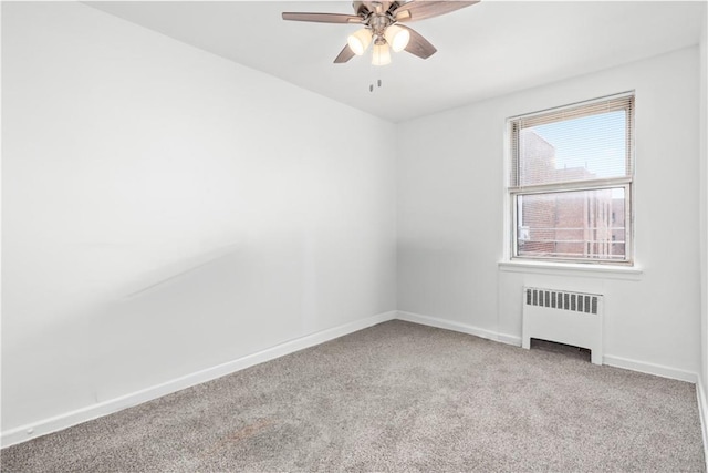 carpeted empty room with radiator heating unit and ceiling fan