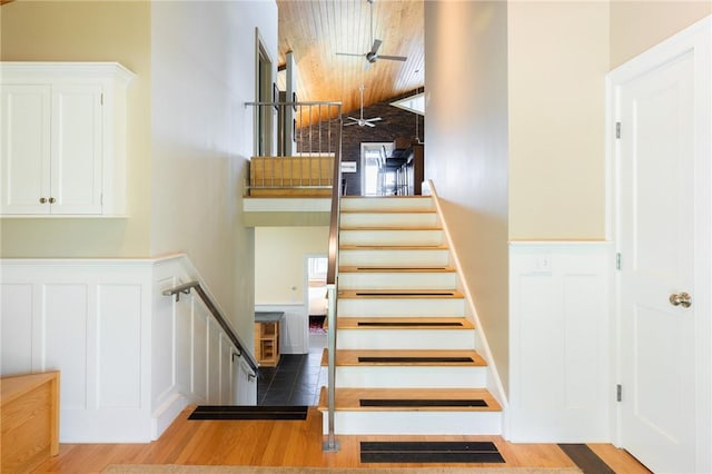 stairs featuring hardwood / wood-style flooring, ceiling fan, and wooden ceiling