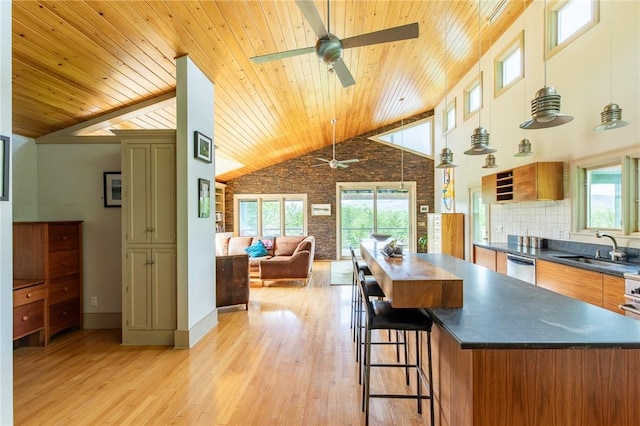 kitchen with sink, decorative light fixtures, high vaulted ceiling, wooden ceiling, and light hardwood / wood-style floors