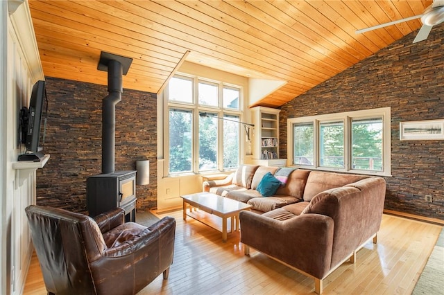 living room with wooden ceiling, a wood stove, high vaulted ceiling, ceiling fan, and light wood-type flooring