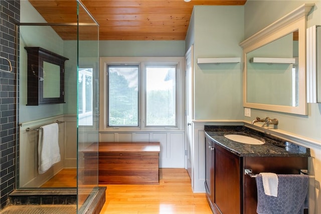 bathroom with hardwood / wood-style flooring, vanity, wood ceiling, and a shower with door