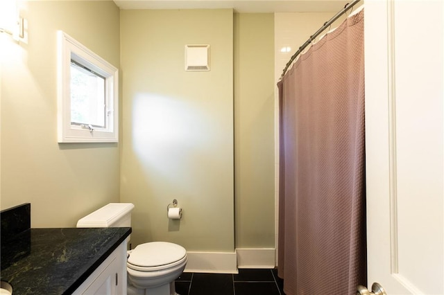 bathroom with tile patterned flooring, vanity, toilet, and walk in shower