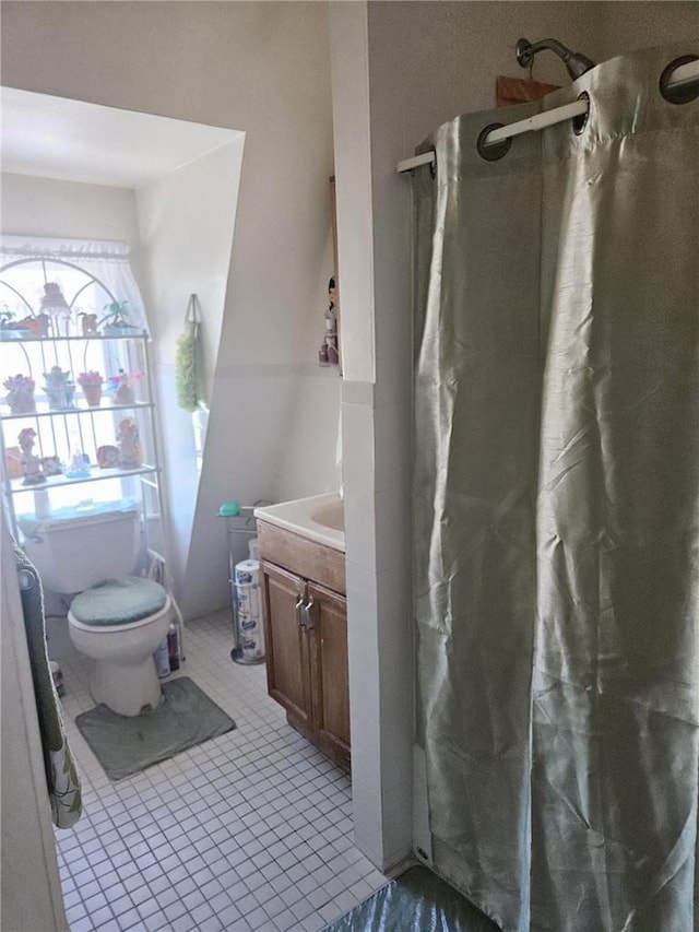 bathroom featuring tile patterned flooring, vanity, toilet, and curtained shower