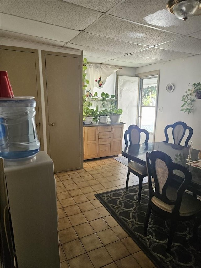 dining area featuring light tile patterned floors and a drop ceiling