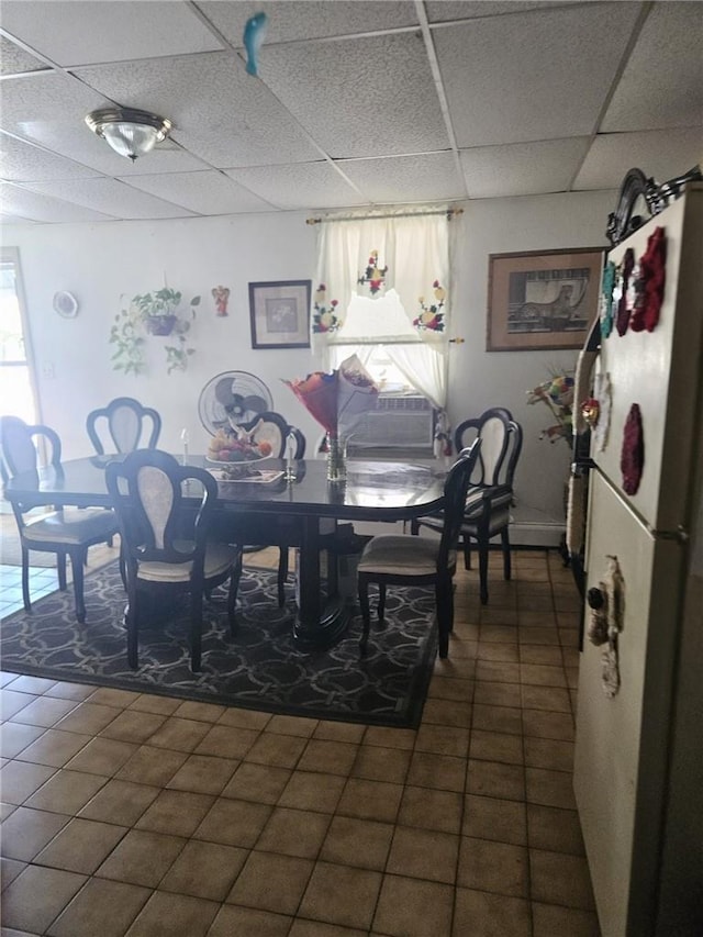 tiled dining area with a paneled ceiling