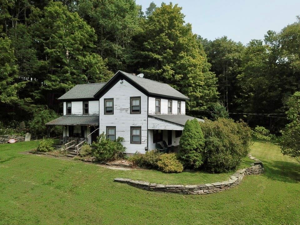 back of house featuring a lawn and a porch