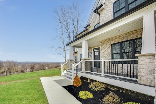 view of side of property featuring a lawn and covered porch