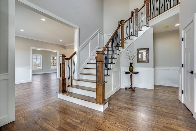 stairway with hardwood / wood-style flooring and crown molding