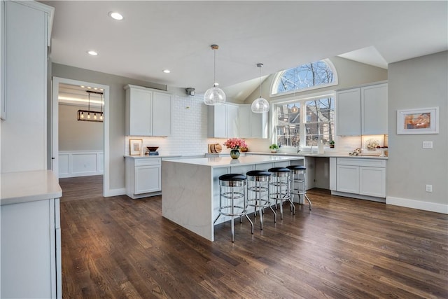 kitchen with white cabinetry, a center island, and dark hardwood / wood-style floors