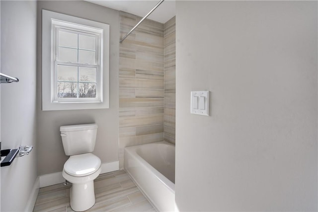 bathroom with toilet and tiled shower / bath