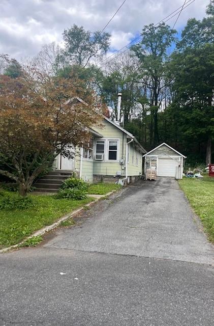 view of front of property featuring an outbuilding, a garage, and a front lawn