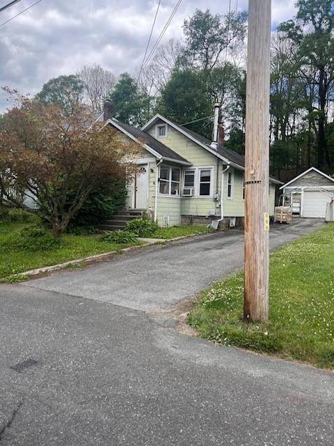 view of front of home with a front yard, an outbuilding, and a garage