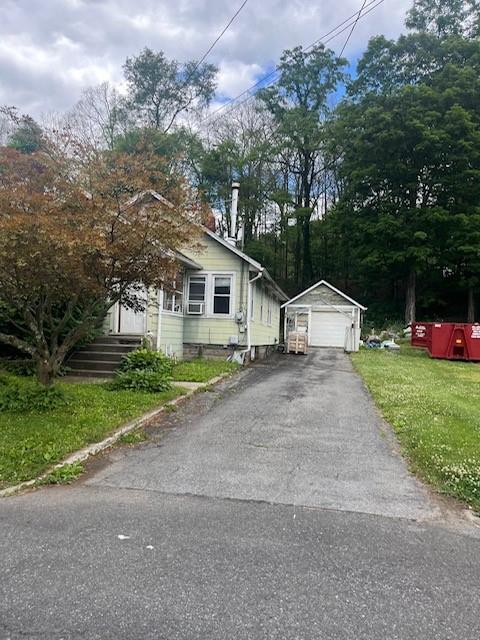 view of front of property with an outbuilding, a garage, and a front lawn