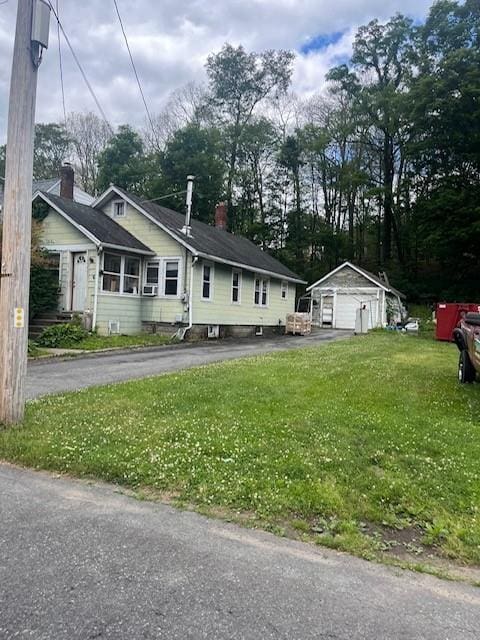 view of front of house featuring an outbuilding and a front yard