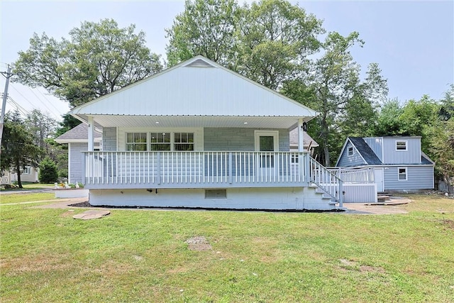 back of house with covered porch and a lawn