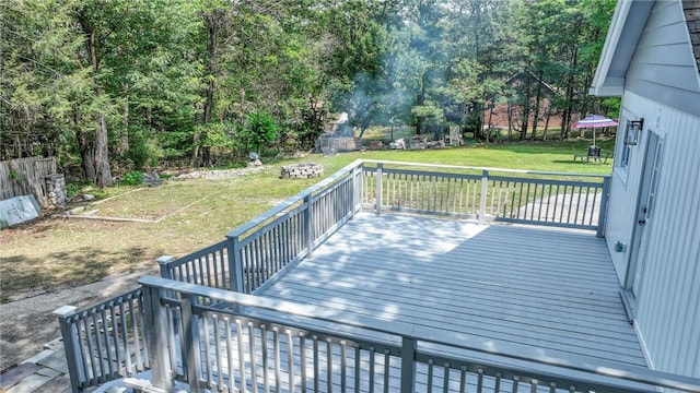 wooden terrace featuring a lawn