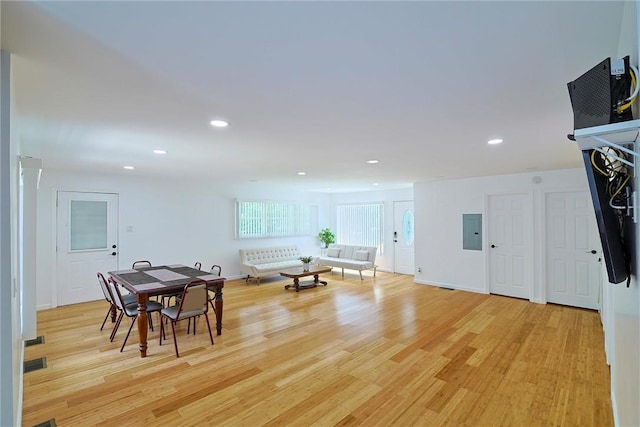 dining area featuring electric panel and light hardwood / wood-style floors