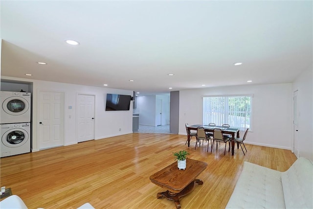 living room with light hardwood / wood-style flooring and stacked washer and clothes dryer