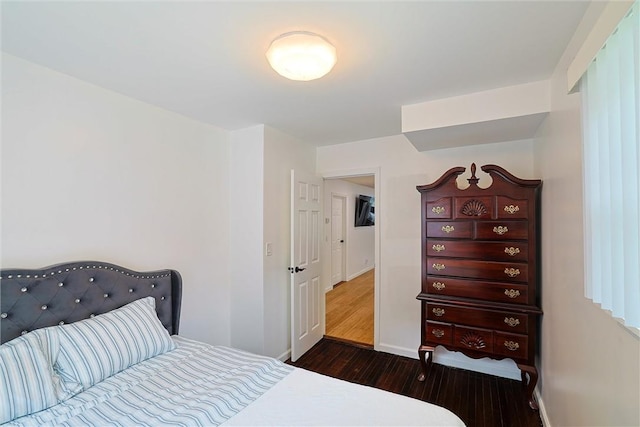 bedroom with dark hardwood / wood-style flooring