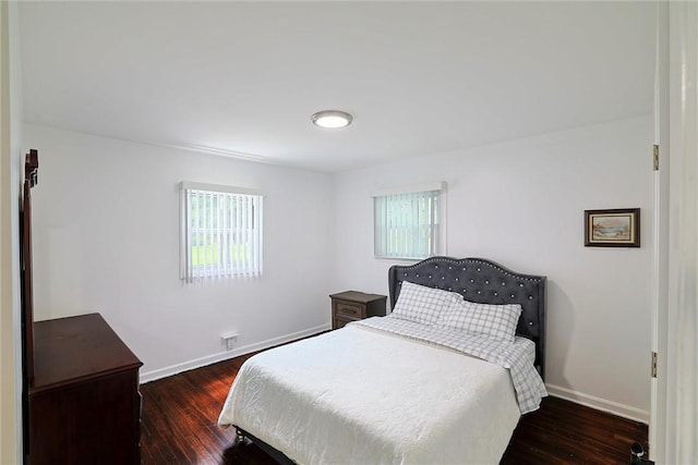 bedroom featuring multiple windows and dark hardwood / wood-style floors