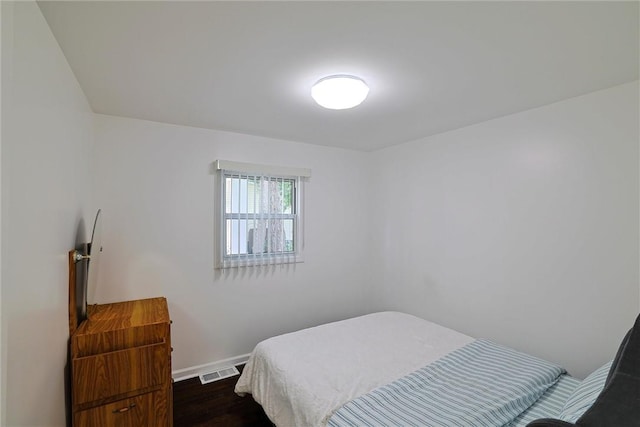 bedroom with dark hardwood / wood-style floors