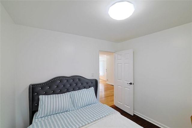 bedroom with dark hardwood / wood-style flooring