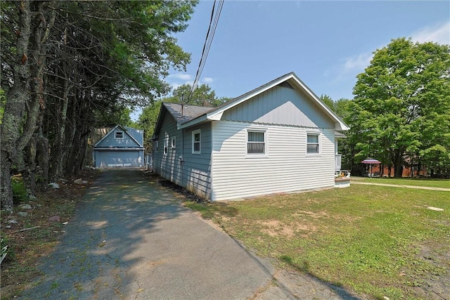 view of side of home with an outbuilding, a yard, and a garage