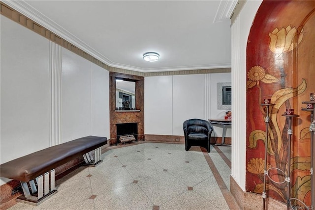 living area with a large fireplace and ornamental molding