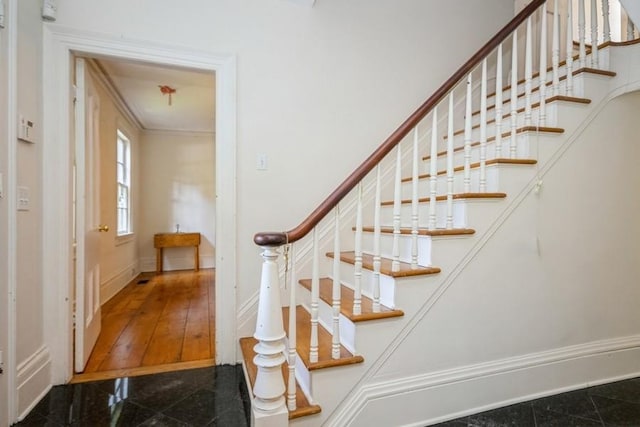 stairway with hardwood / wood-style flooring and crown molding