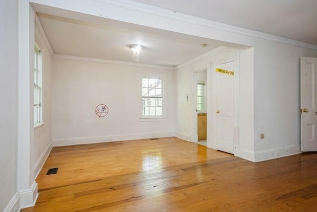 empty room featuring wood-type flooring and ornamental molding