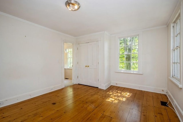 empty room featuring wood-type flooring and ornamental molding