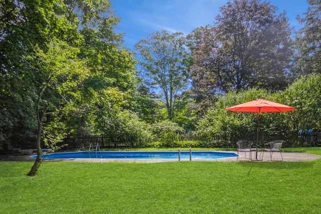 view of swimming pool with a yard